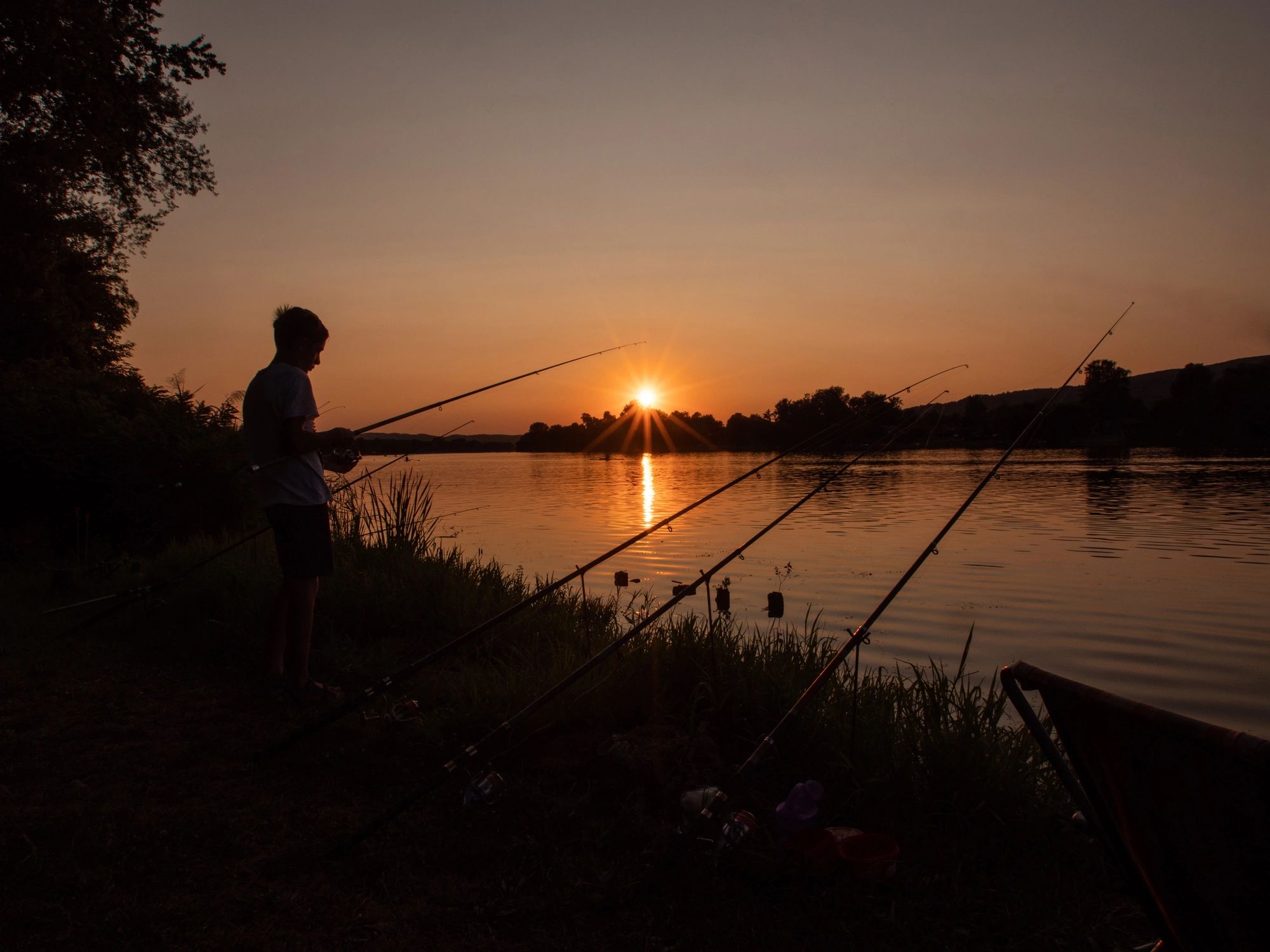 Young person fishing outdoors by the water