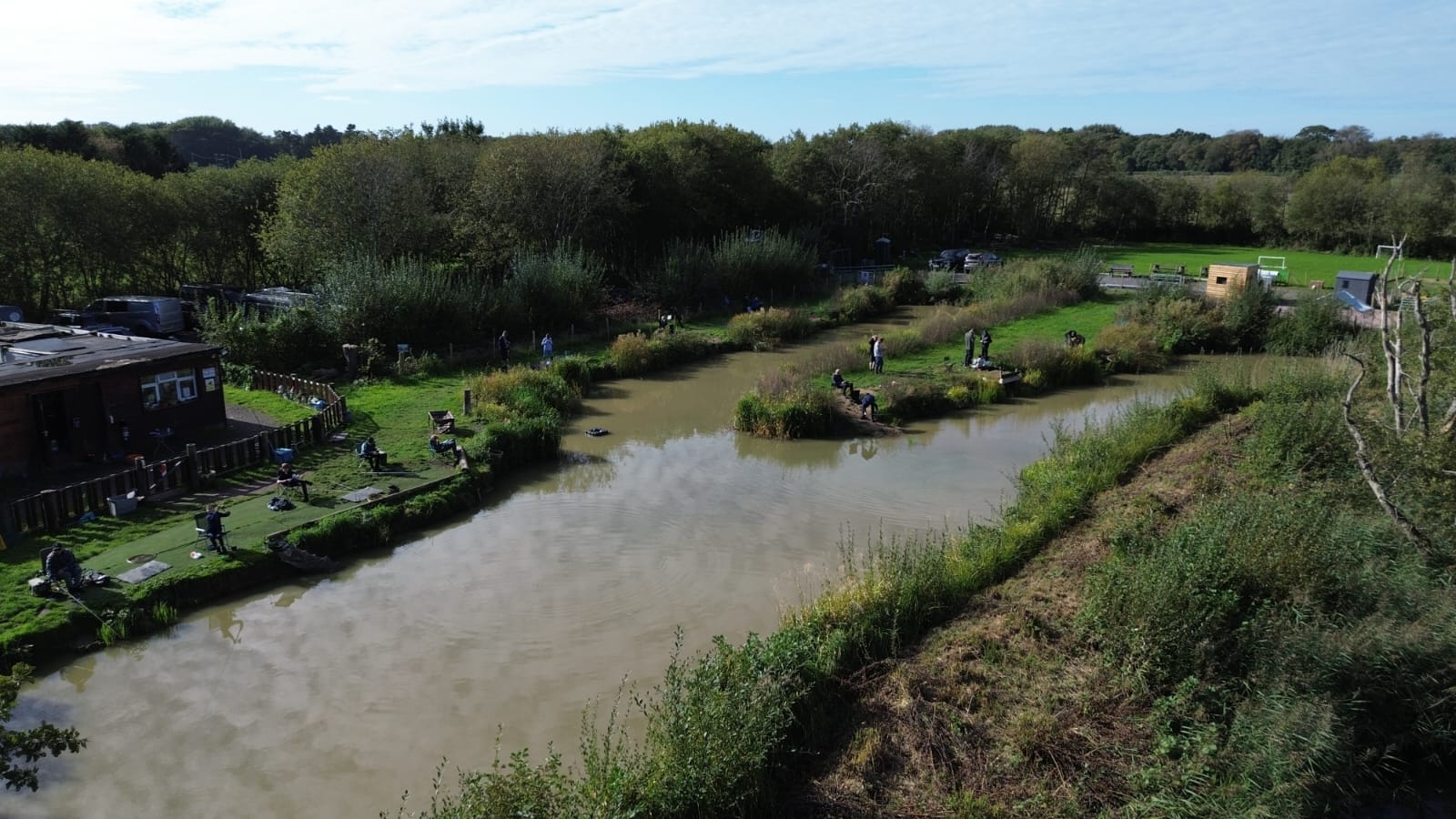 Overhead view of Owl Tree Pond with anglers, grassy banks and surrounding trees